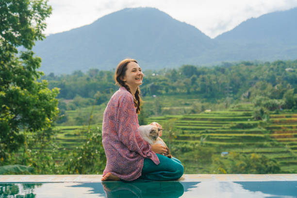 istock Woman sitting at the pool with her cat  on Bali 2067364521