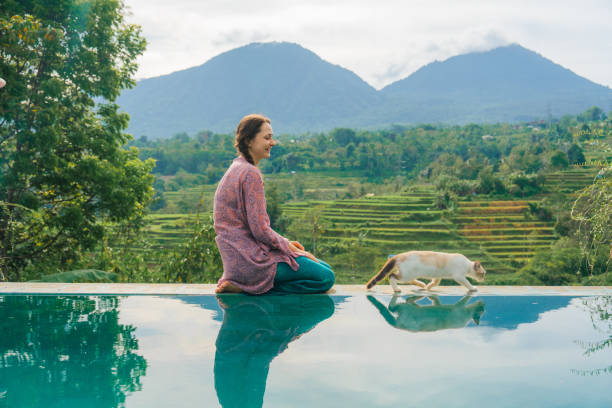 istock Woman sitting at the pool with her cat  on Bali 2067364523