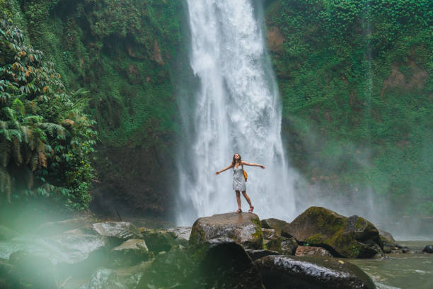 istock Woman standing near the refreshing waterfall on Bali 2067370272