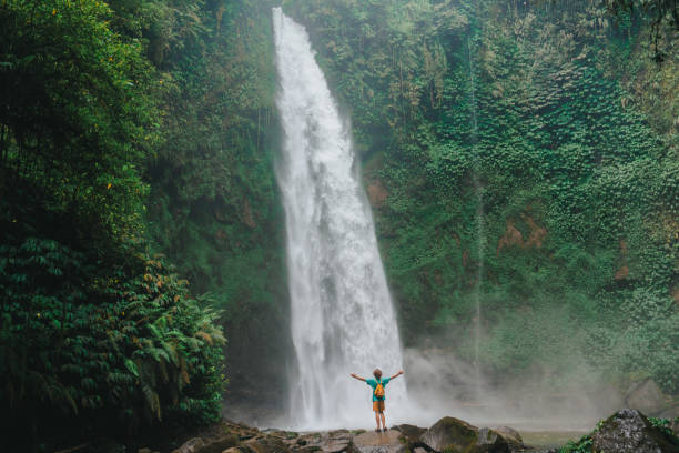 istock Man enjoying tropical waterfall  on Bali 2067372935