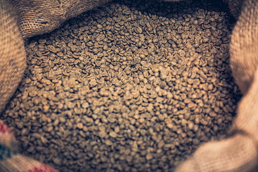 coffee beans with coffe cup, cane sugar on linen cloth background top view.