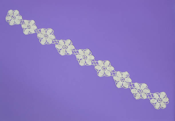 Handmade crochet lace in white on a  purple background.