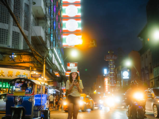 istock Woman using smartphone while exploring Chinatown in Bangkok during vacation 2067410714
