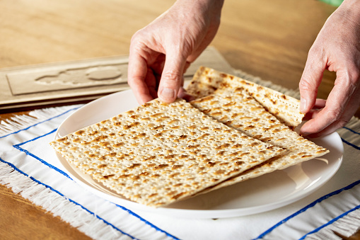 A man celebrates the Jewish holiday of Passover. holding matzo in his hands