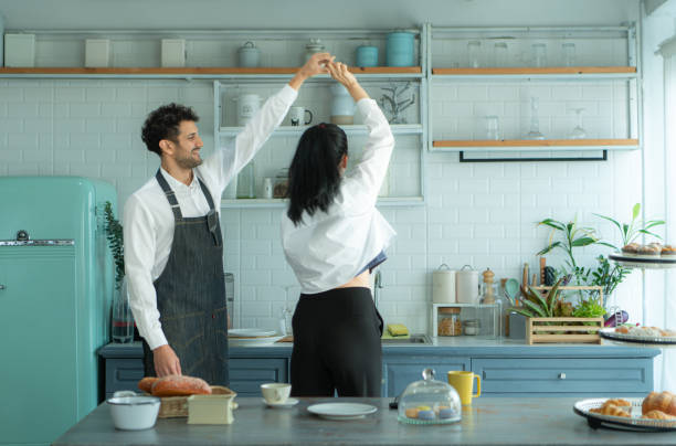 istock A husband wears an apron while cooking dinner with his wife. He was dancing happily before entering the kitchen to cook. 2067549461
