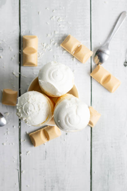 istock Vanilla ice cream in waffle cones on a white wooden background. 2067551117