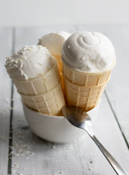 istock Vanilla ice cream in waffle cones on a white wooden background. 2067551118