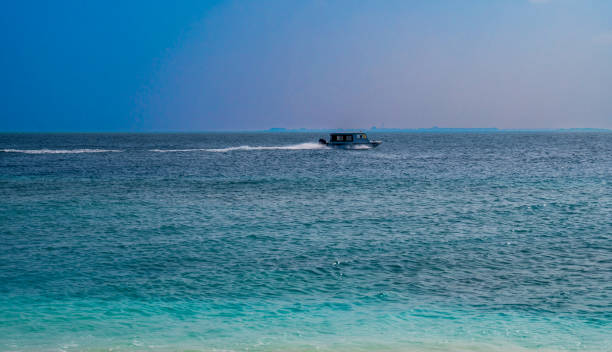 istock White boat floats fast on the surface of the sea. 2067568021