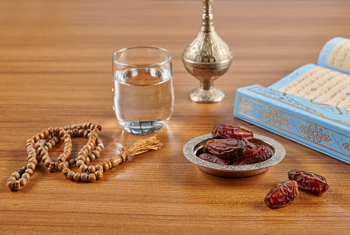 Ramadan date water and turkish style zinc silver plate, rosary style on the wooden table.