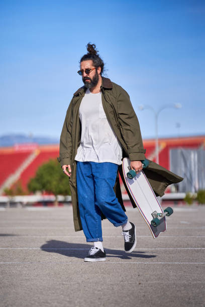 istock Trendy hipster man strolling on asphalt road with skateboard 2067647237