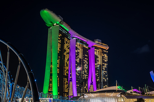 Singapore, 24 January 2024: Marina Bay Sands in Singapore its vibrant illumination mirrored in surrounding waters. ArtScience Museum and Helix Bridge enhance to vibrant, modern skyline