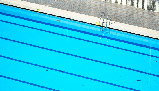 Top view swimming pool outlined by bold lanes, inviting swimmers to glide through clear turquoise water. lanes, neatly divided by marker lines, perfect for training and competition