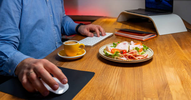 istock Businessman enjoying a healthy meal and coffee while working at a modern workspace 2067695225
