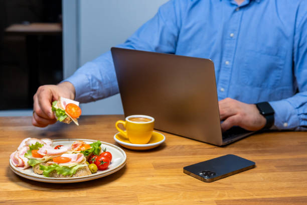 istock Businessman enjoying a healthy meal and coffee while working at a modern workspace 2067695237