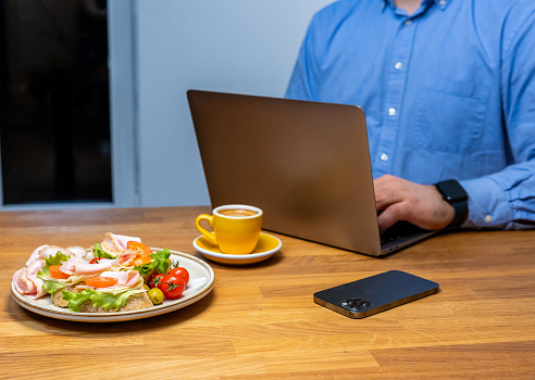 Businessman enjoying a healthy meal and coffee while working at a modern workspace