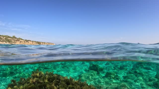 Half underwater view of Mediterranean sea with clear turquoise water. Dome shot of clear blue sea water. Slow motion, 4K