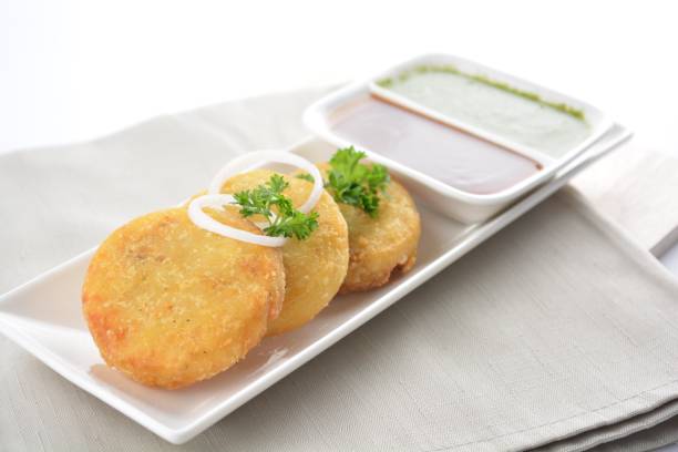 istock Indian deep fried round potato snack hash brown with green yogurt and red chilli sauce breakfast on white background asian chef appetiser halal bakery food restaurant pastry menu for cafe 2067703880