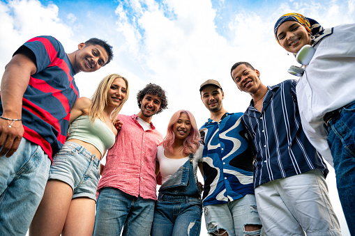 Group of multiethnic teenagers spending time outdoor on a picnic at the park. Concept about generation z, lifestyle and friendship