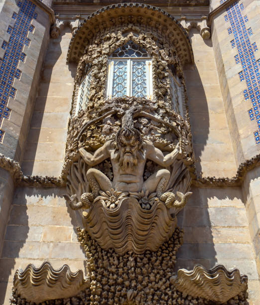 szczegółowy widok groteskowego posągu trytona wyrzeźbionego w kamieniu z rybim ogonem zamiast nóg na muszli z motywami roślinnymi na fasadzie pałacu pena. sintra. portugalia. - chimera zdjęcia i obrazy z banku zdjęć