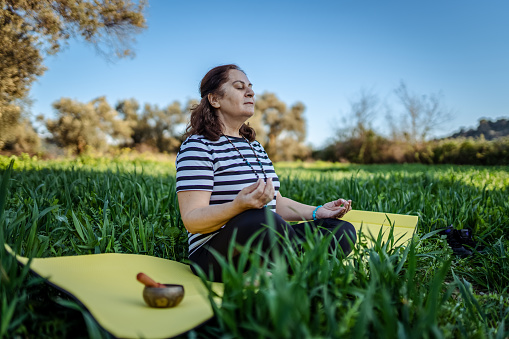 Senior woman meditating in nature