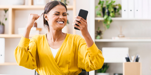 Happy, excited and woman with phone in office, celebrate success, good news text on online discount deal. Email surprise, approved financial loan for ecommerce startup and winning with sales results.