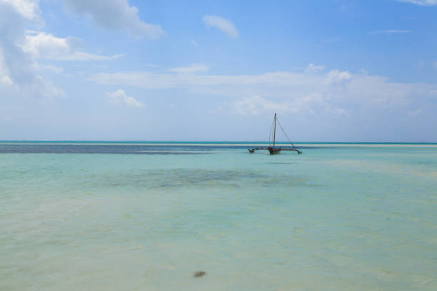 istock Boat in shallow waters with a blue sky background 2067748582