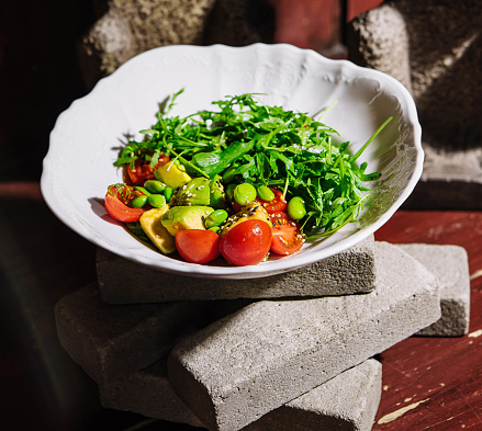 Fresh salad with avocado, cherry tomatoes and arugula