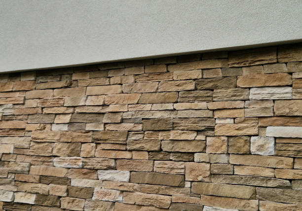 istock Modern gray brown, beige, metal door at the house lined with stone cladding. gutter for drainage of water on the pavement. limestone cladding 2067774979