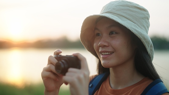 Asian girl taking a photo while traveling at nature.