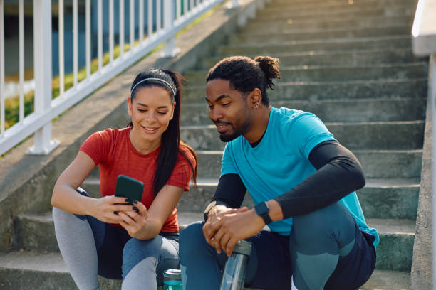 istock Happy athletic couple using mobile phone outdoors. 2067783705