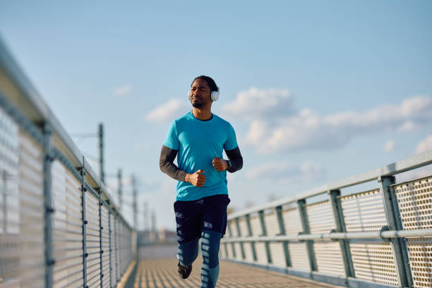 istock African American athlete running over the bridge and looking away. 2067788076