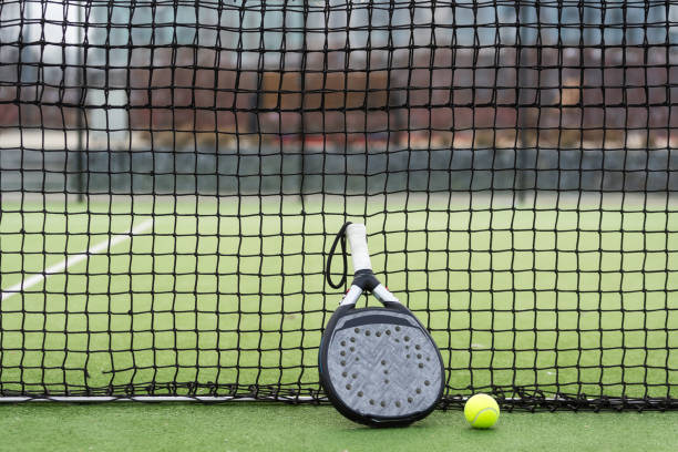istock White professional paddle tennis racket with natural lighting on blue background. Horizontal sport theme poster, greeting cards, headers, website and app 2067788087