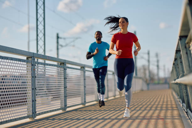 istock Athletic couple jogging while having sports training outdoors. 2067789411