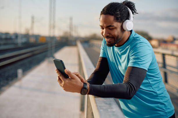 istock Happy black athlete using smart phone outdoors. 2067798041