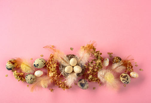 Easter composition with quail eggs, feathers, and dried flowers. Top view.