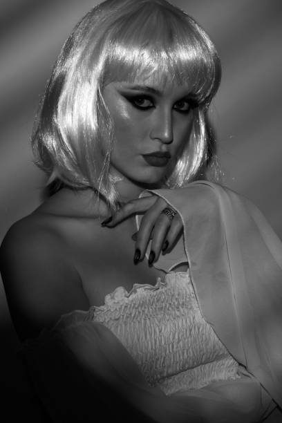 istock Beautiful woman with white wig illuminated by bright light through blinds 2067814989