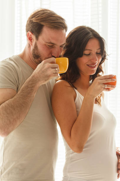 Two latin american business colleagues are taking a tea break, enjoying conversation and tea in a modern office