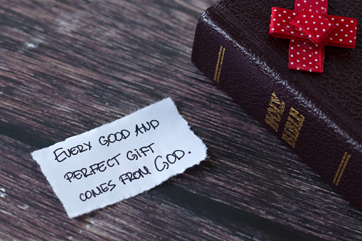 Every good and perfect gift comes from God, handwritten quote with holy bible book on wood. Christian blessings and talents from Jesus Christ, biblical concept.