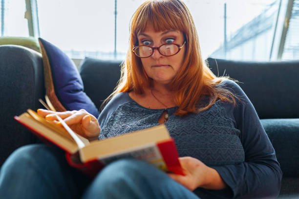 istock Portrait red-haired woman reading novel book 2067847122
