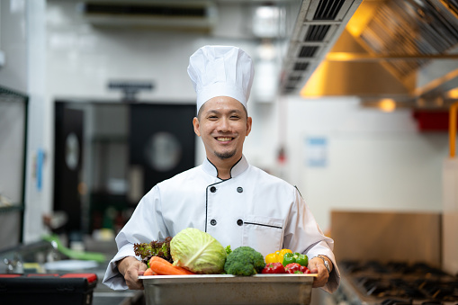 Portrait of male chinese chef carrying her fresh ingredients out from chiller