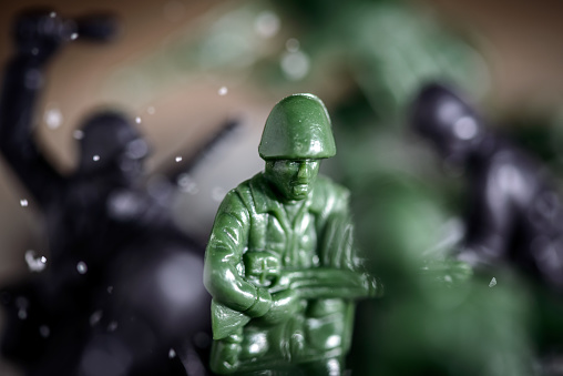 Toy soldier fighting in battle, sugar and coffee used to simulate snow, soil and explosions