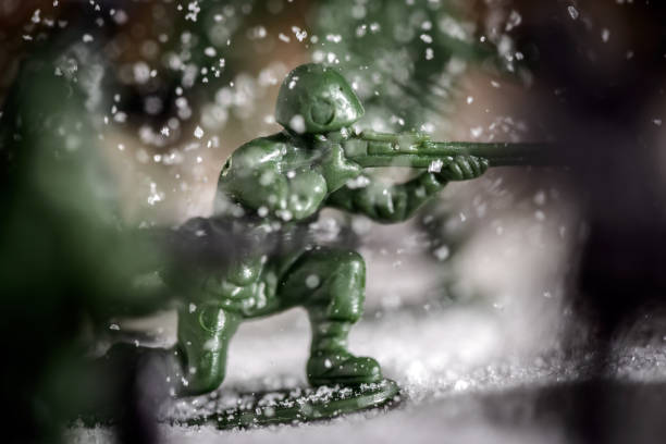 Toy soldier fighting in battle, sugar and coffee used to simulate snow, soil and explosions