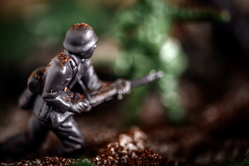Toy soldier fighting in battle, sugar and coffee used to simulate snow, soil and explosions