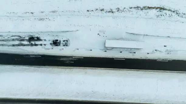 Photo of Drone photography of lorry accident site, abandoned trailer and burned up asphalt in a highway during winter morning