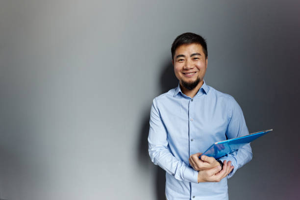 istock Happy Chinese businessman against the wall. 2067935211