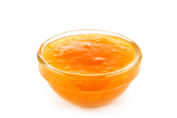 Sweet apricot jam in bowl isolated on white background