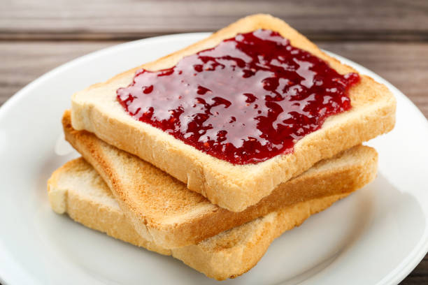 istock Toasts with raspberry jam in plate on wooden table 2067960620