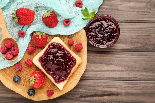 istock Toast with jam and ripe berries on wooden table 2067970333