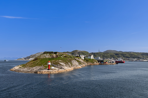 Bodo - Norway. June 17, 2023: A summer view from a ferry to Lofoten Island captures Bodo, with its vibrant port and unique landscape under a blue sky, showcasing a blend of natural beauty and urban life in the Arctic Circle