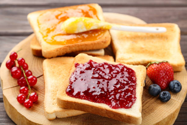 istock Toasts with jam and ripe berries on wooden table 2067973602